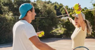Photo of a loving couple playing tennis together on a tennis court